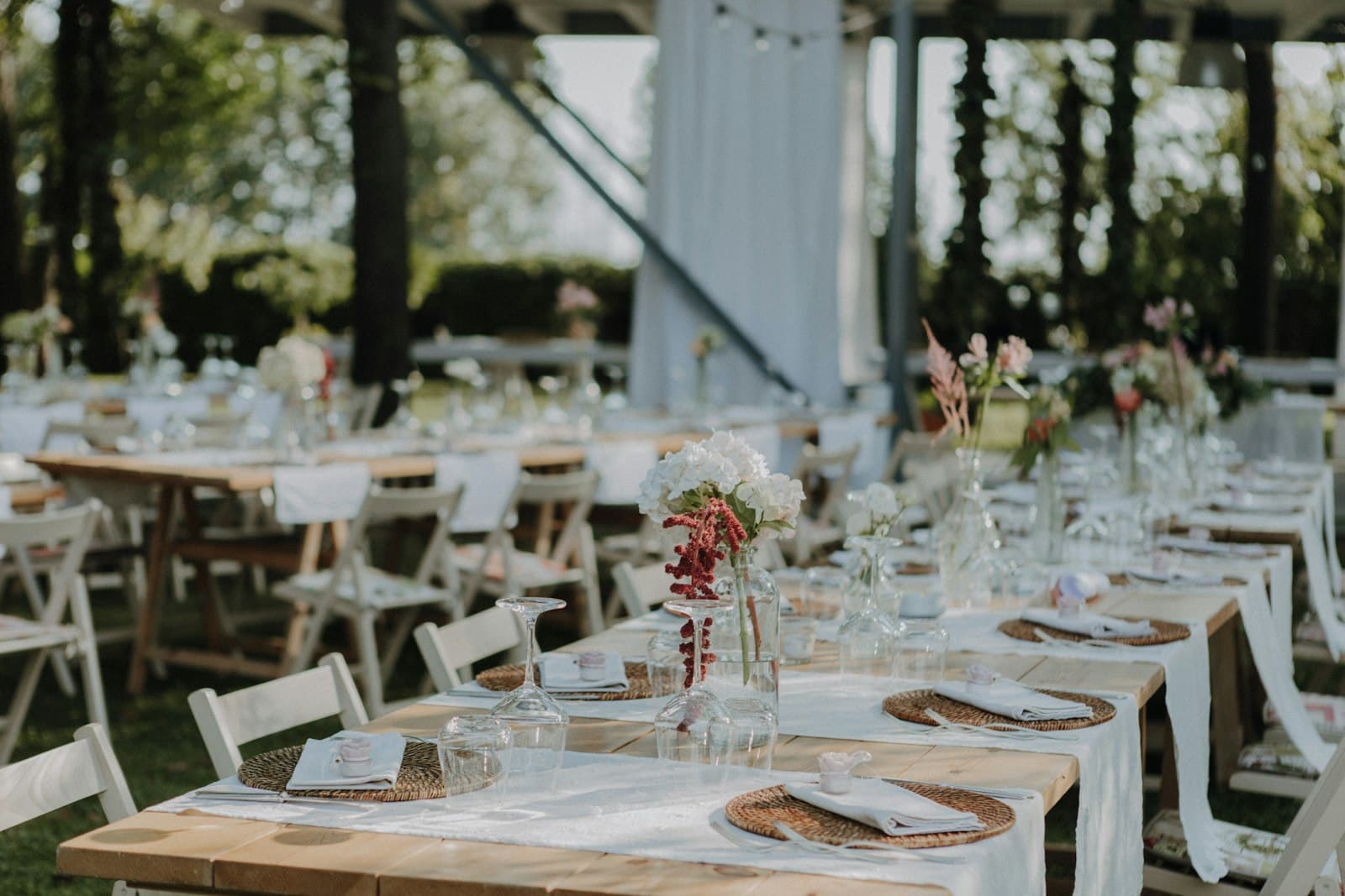 Outdoor wedding reception tables set under a white pergola
